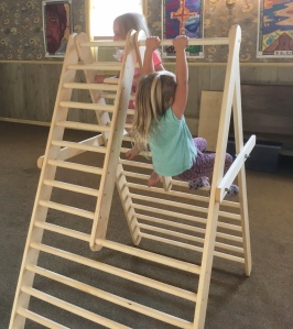 Children climbing and swinging on an a-frame 